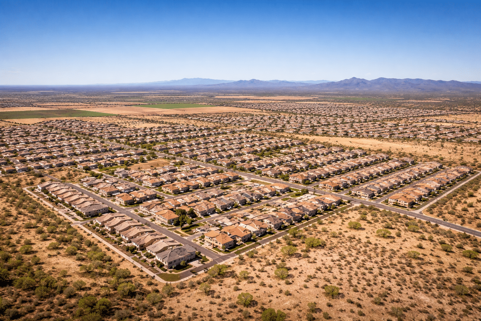 Casa Grande Arizona housing market aerial view of new development across open Pinal County desert plain — West USA Realty