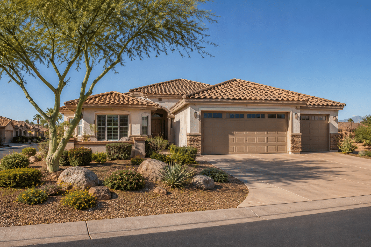 A single-story ranch-style home with stucco exterior in soft cream- adobe tone