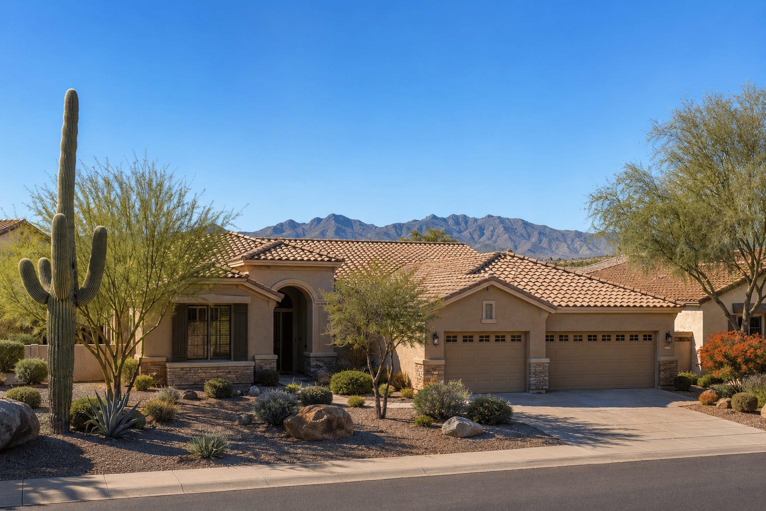 single-story tan-stucco home with a tile roof and a three-car garage on a quiet residential street in a north Peoria, Arizona 55-plus neighborhood