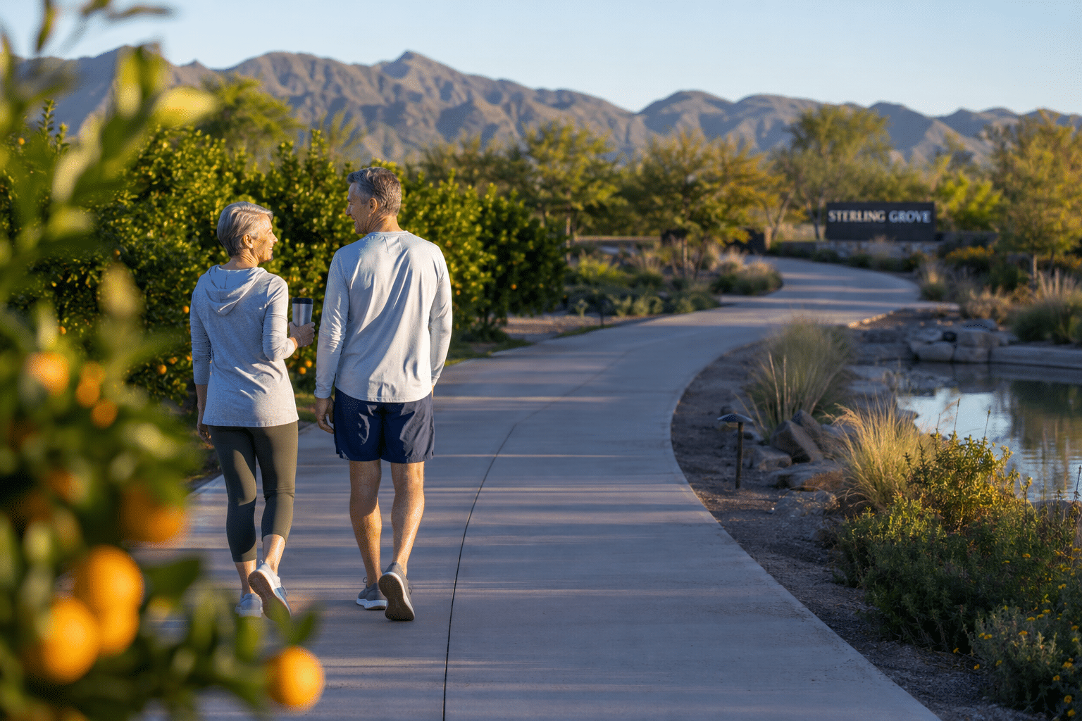 ouple, different gender and in their early sixties, walking together along a paved community trail at Sterling Grove in Surprise Arizona