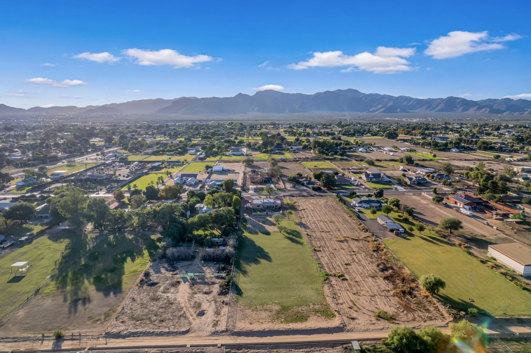 Aerial view of the lot and surrounding horse properties with mountains in the distance