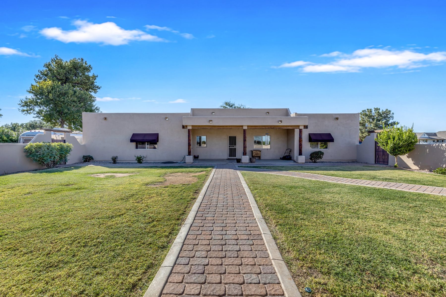 Back of the house with covered patio and paver walkway