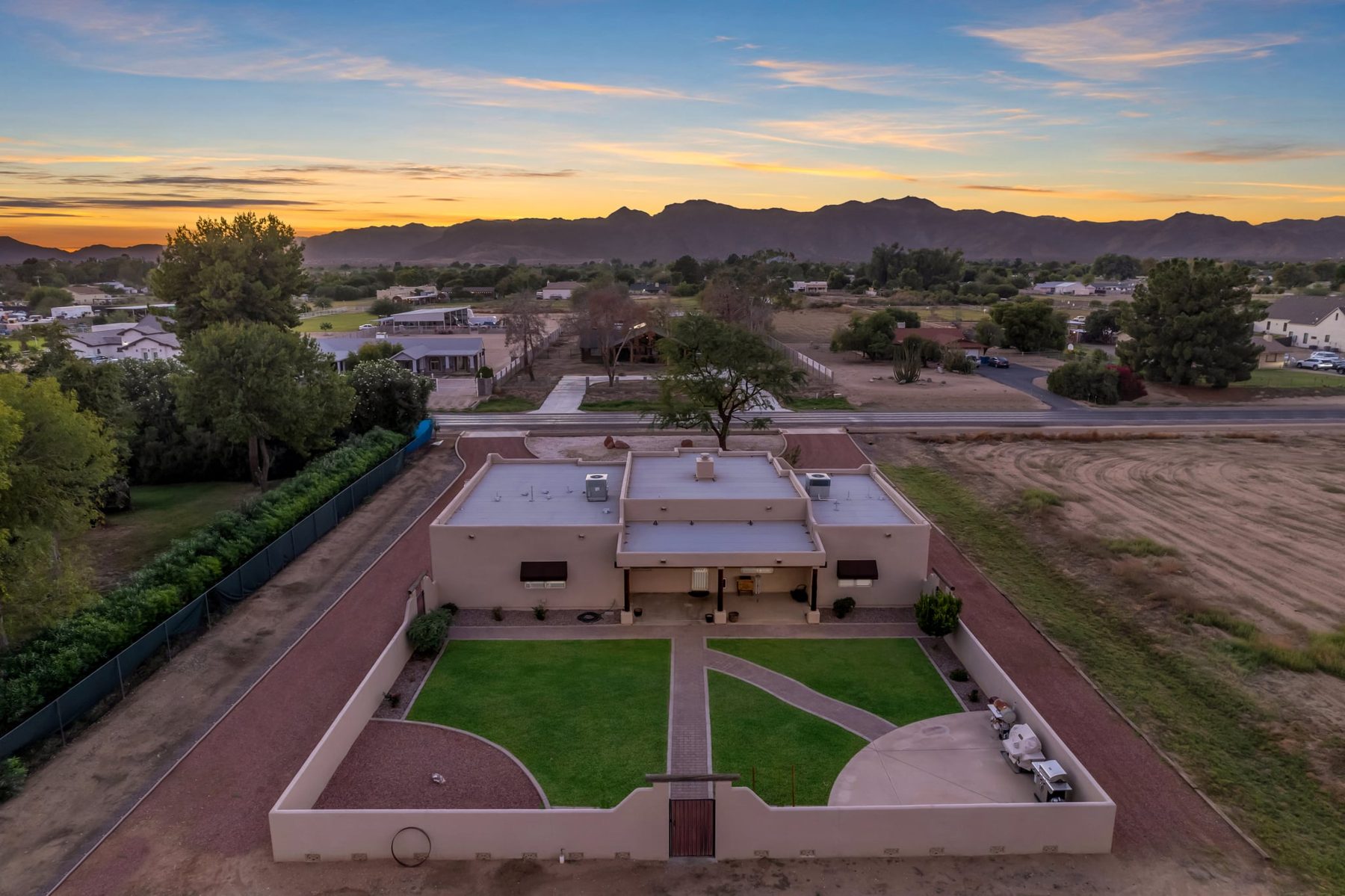 Twilight aerial of the walled backyard with the White Tank Mountains behind