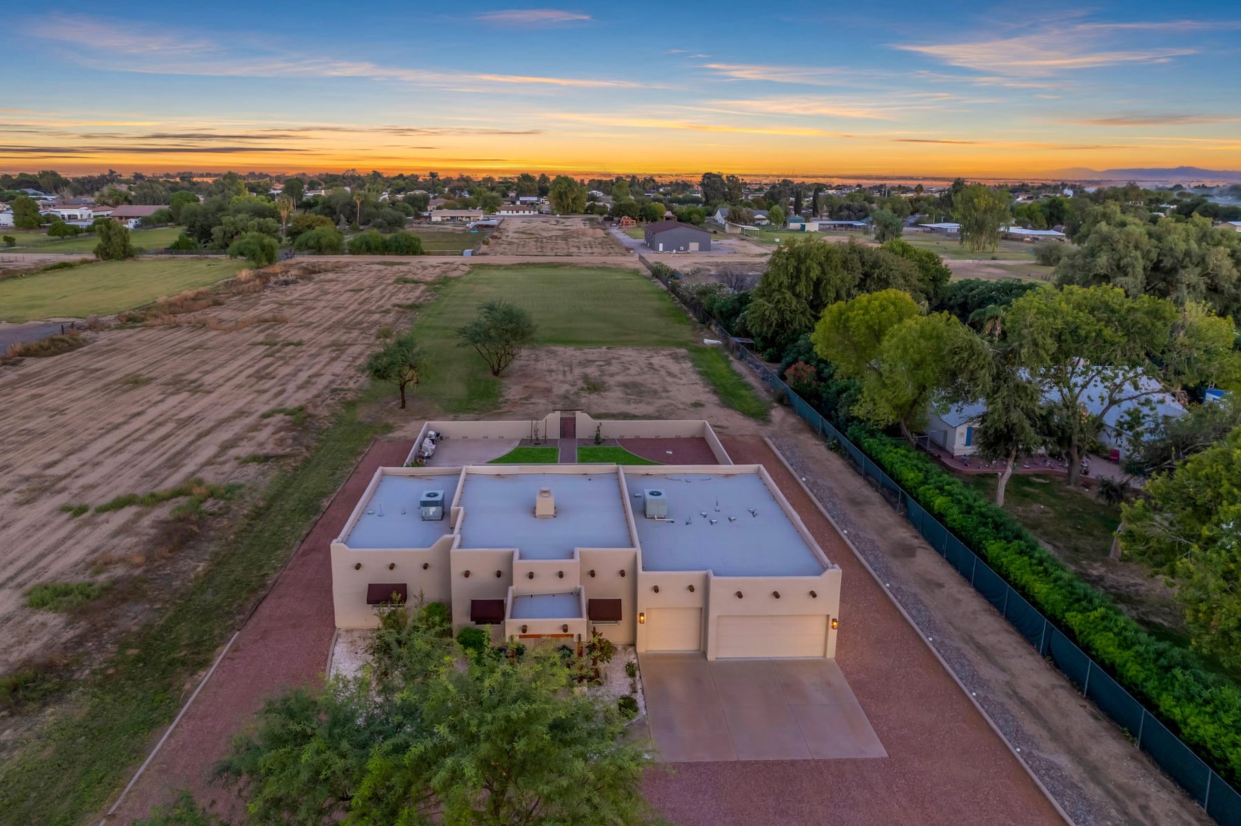 Twilight aerial of the front of the home with the pasture behind